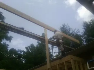 Carpenter setting a ridge beam over a new addition frame — Ice Dam Removal by Roofing Brothers in Fort Jennings