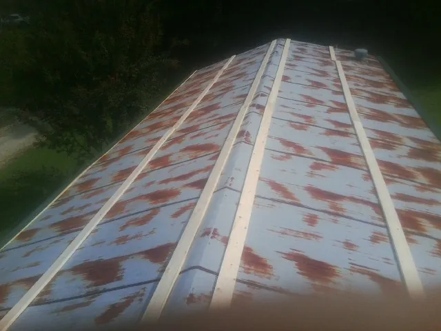 Rusted metal roof panels with new wood purlins before replacement — Storm Damage Roof Repair in Fort Jennings by Roofing Brothers